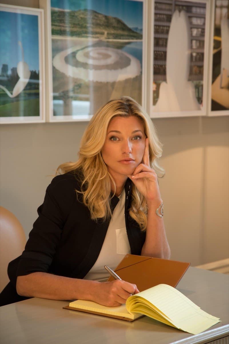 Nicole Junkerman writing thoughtfully in a notebook at her desk
